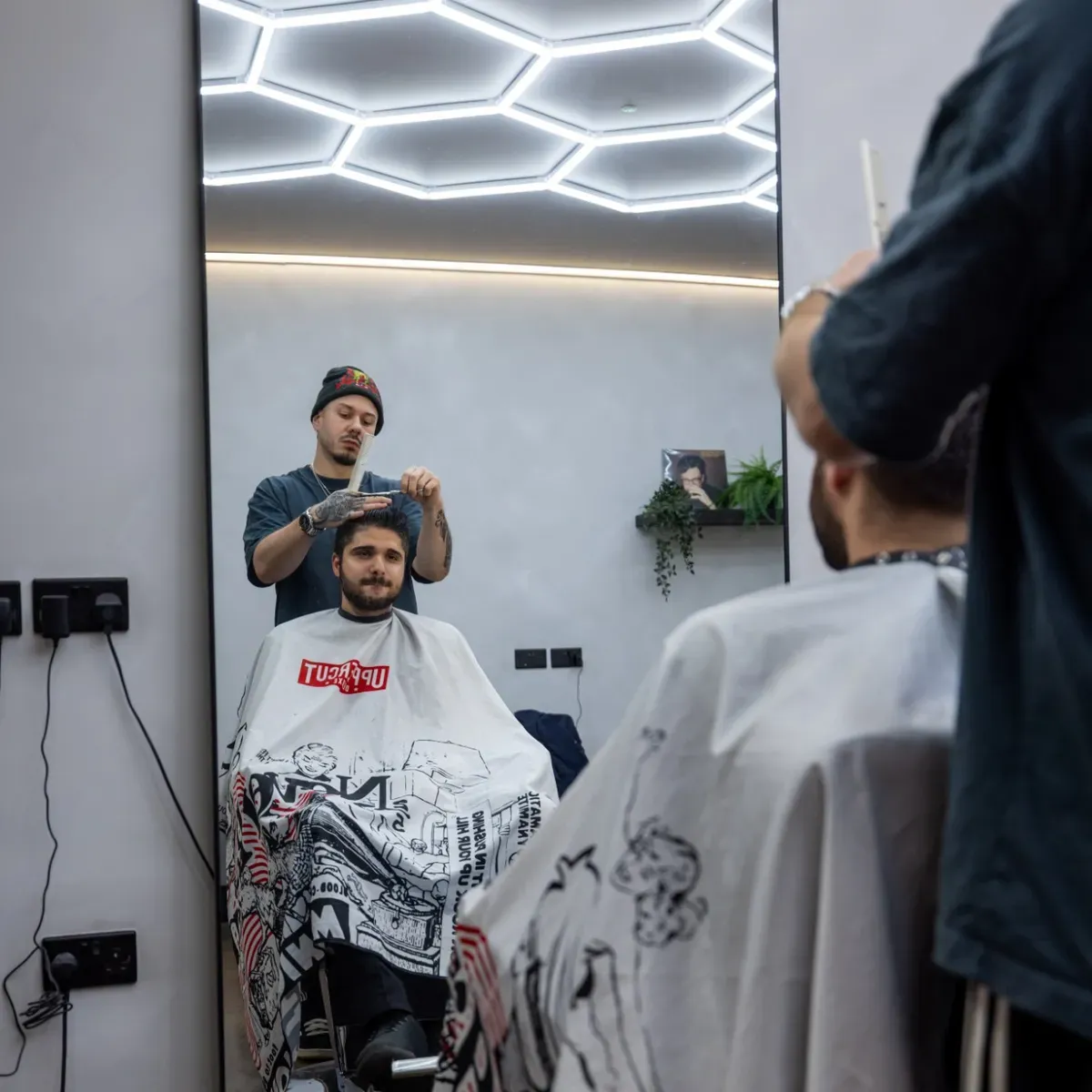 Kristian cutting, seen in the mirror under the hex lights